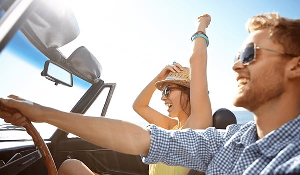 Summer car-prep checklist couple driving in convertible in summer