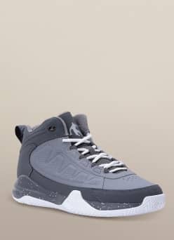 A grey basketball sneaker is pictured on a beige backdrop.