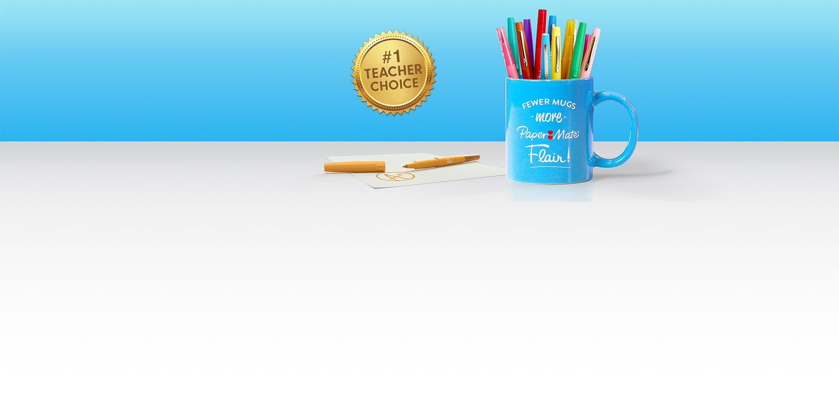 A blue Paper Mate Flair branded cup with Paper Mate Flair pens in it sits atop a desk with a Number One Teacher Choice medallion on the side.