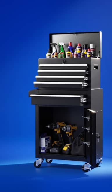 Tall black rolling tool chest with open drawers holding power tools and spray bottles.