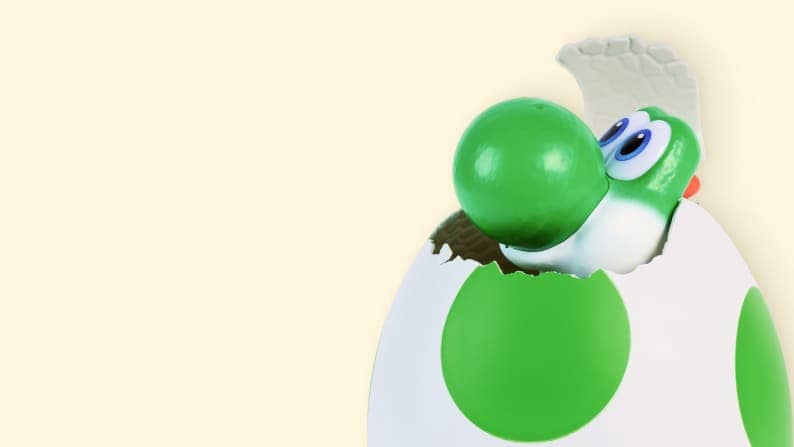 Green dinosaur cracking out of a green and white polka dot egg.