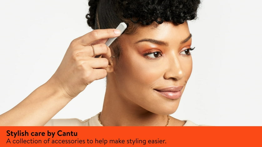 A woman combs her edges with a Cantu brush designed for baby hairs.