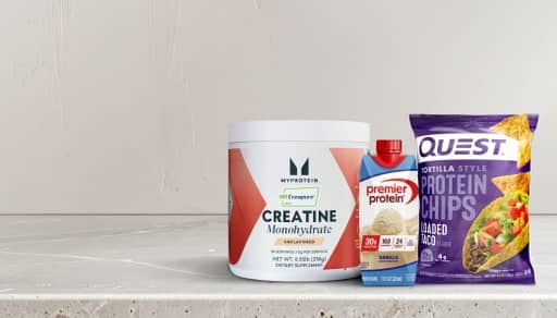 Creatine supplement, Quest chips and a protein shake on a countertop.