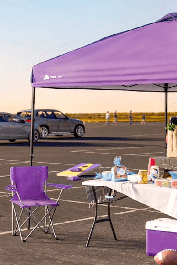 Image shows Tailgating sports set up with camping chair, cooler and canopy in color purple.