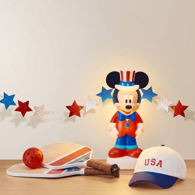 A USA hat, pickleball rackets and ball, Mickey Mouse lamp in a USA theme.