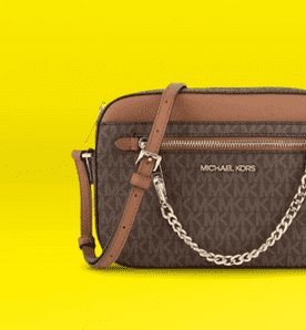 Image shows a brown Michael Kors crossbody bag with a chain strap on a yellow background.