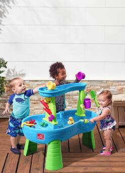 Toddlers shown playing with a water table.