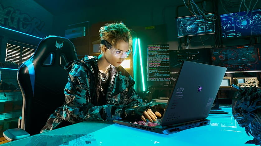 Person looking focused at a laptop while playing a video game.