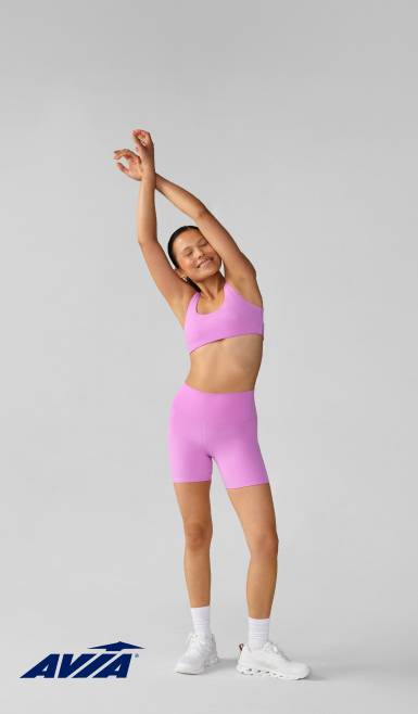 Avia logo in the bottom left corner. A woman is wearing a pink active set.