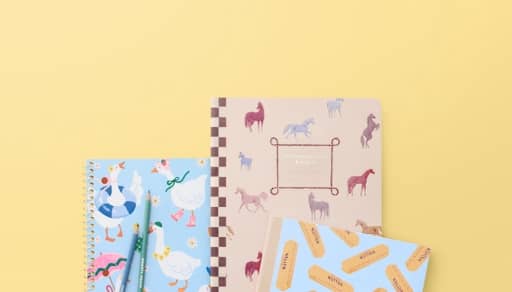 Patterned notebooks on a pale yellow background.