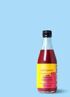A bottle of bettergoods hibiscus grenadine against a light blue background.