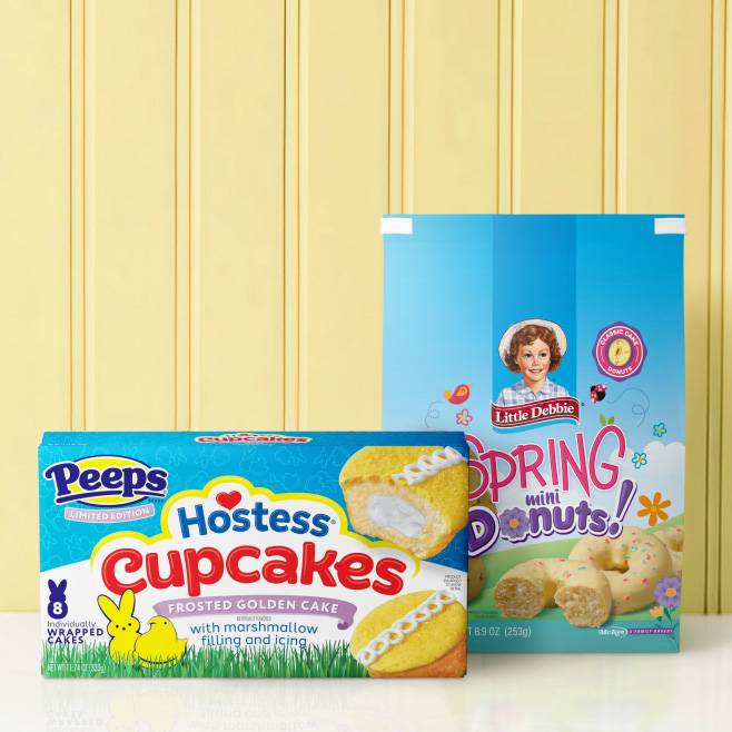 Hostess Peeps limited edition cupcakes and Little Debbie spring mini donuts against a light yellow paneled background.