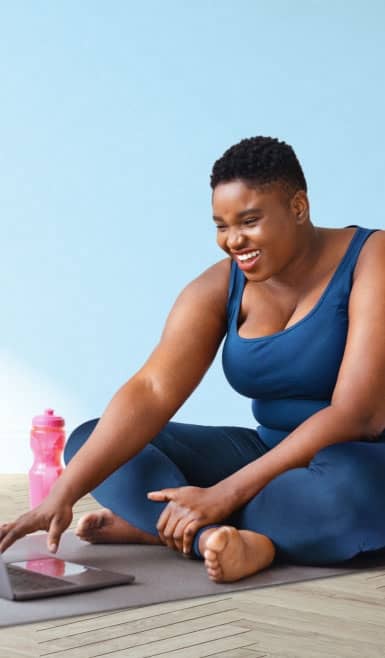 Woman on a yoga mat with a pink water bottle nearby