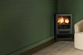 An image of a green fireplace against a green wall, next to an ivory chair.