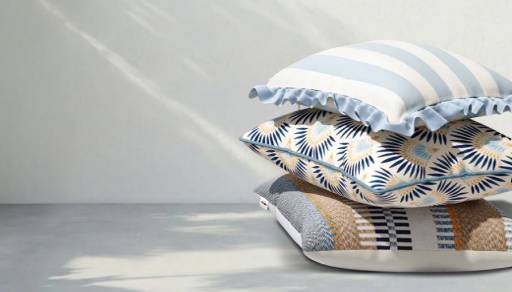 Striped and geometric-patterned pillows on a white background.