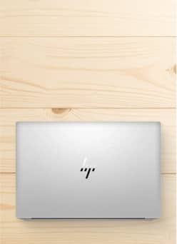 HP laptop shown against wooden background.