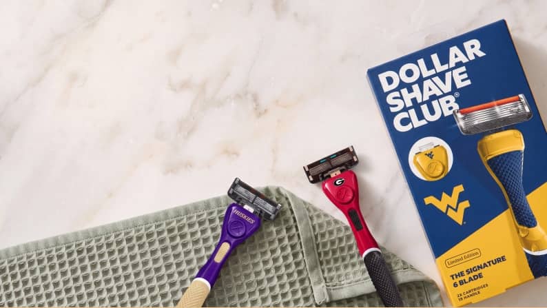 Dollar Shave Club razors and cartridge on a green towel with Dollar Shave Club The Signature six blade packaging.