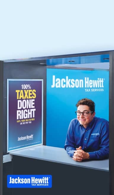 A man sitting in a Jackson Hewitt kiosk booth.