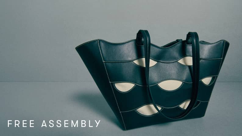 Dark green cutout tote bag displayed against soft gray background.