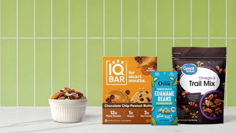 A box of IQ Bar chocolate chip peanut butter protein bars, The Only Bean edamame beans snack pack and Great Value Omega-3 Trail Mix bag is shown.