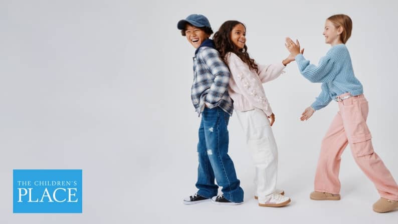 Two girls and one boy are shown. Girls wear cargo pants, sweaters, sneakers and clogs. The boy wears a plaid flannel hooded top, jeans and sneakers.