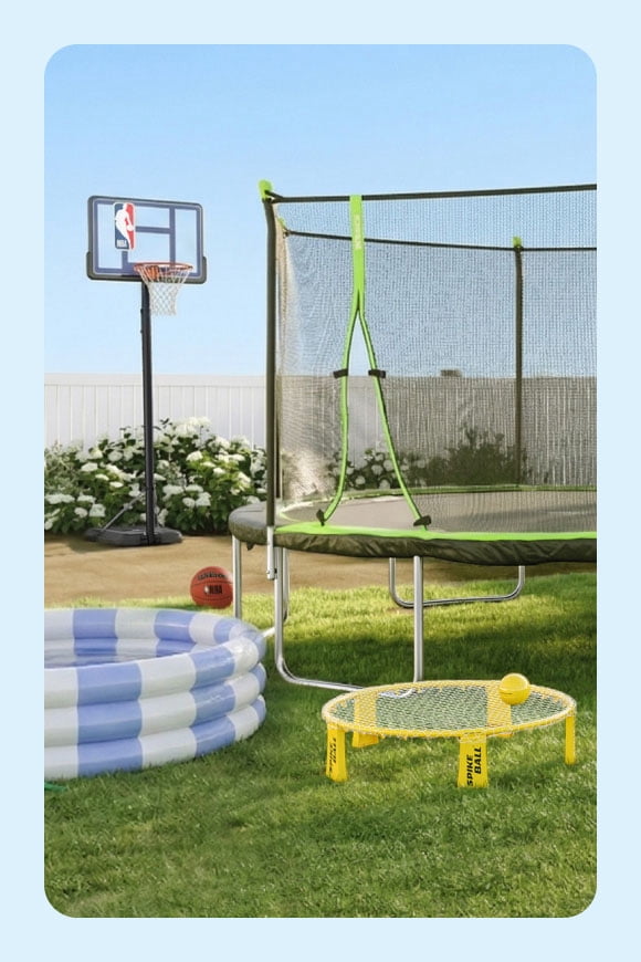 Two trampolines, a pool and a basketball hoop in a backyard.