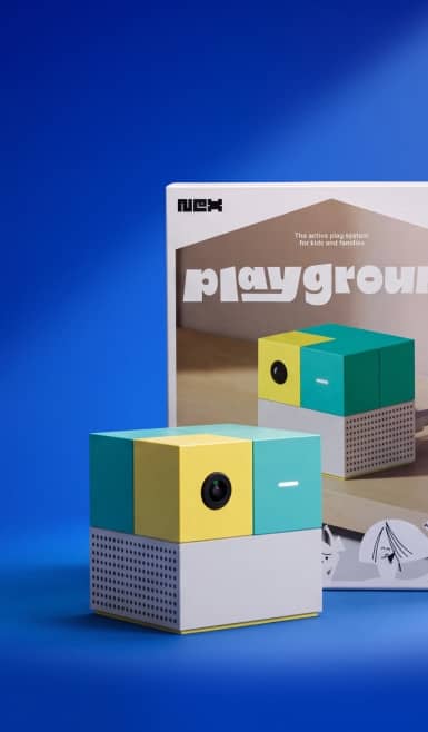 Playground cube shaped camera toy with colorful panels in front of its box.