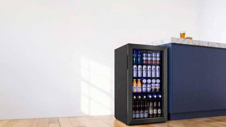 A fully stocked mini fridge with a glass door.