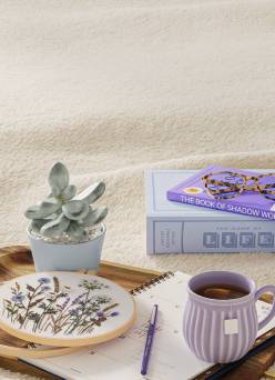 Digital detox items, including books, an embroidery kit, and a journal, are featured next to a mug of tea.