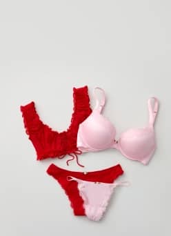 A red lingerie set and a pink lingerie set are layered on top of one another.
