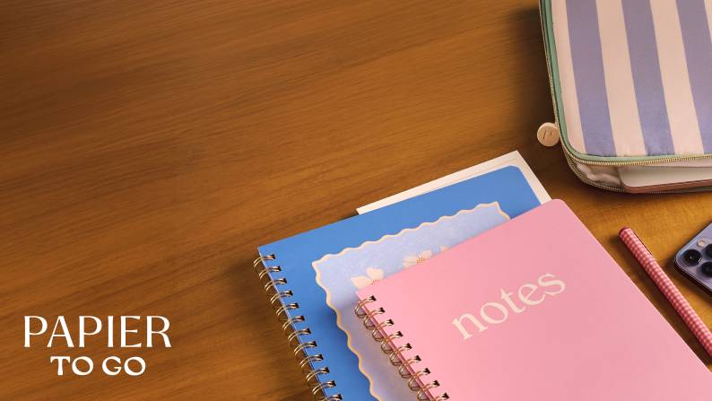 Pink and blue notebooks on a wood desk.