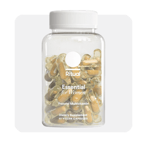 Image shows a clear bottle labeled "Ritual Essential for Women Prenatal Multivitamin" containing yellow capsules, placed against a light background.