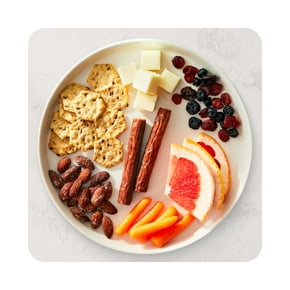A plate of assorted snacks, including cheese, fruit and meat, is shown.