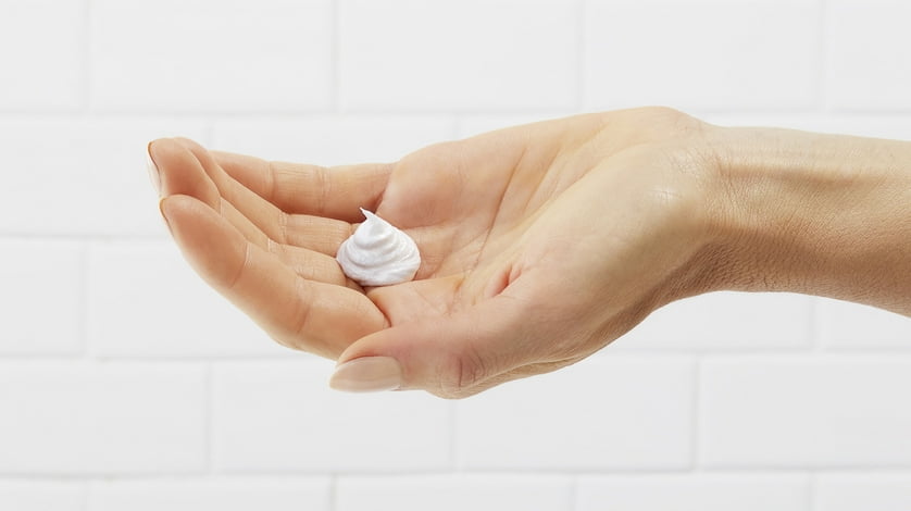 A dollop of shaving cream in an outstretched hand