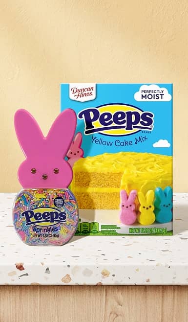 A box of Peeps yellow cake mix box and Peeps bunny sprinkles in front of it is shown.
