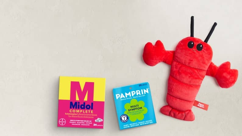 A red plush lobster, Pamprin multisymptom and Midol Complete pain relievers.