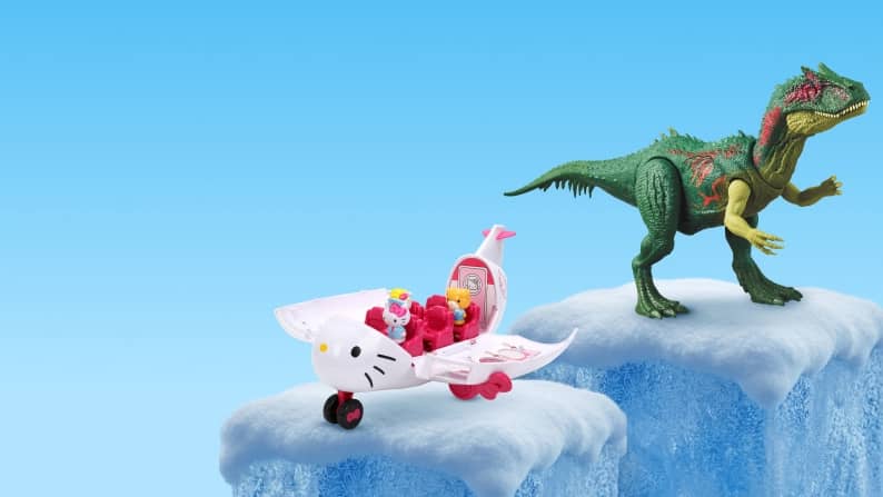 Hello Kitty toy airplane with small figures and a green dinosaur toy on separate ice blocks.
