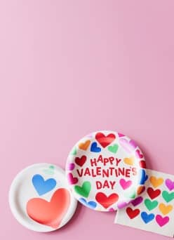 Paper plates and napkins with multi-color hearts.