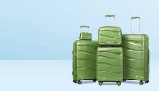 Four green hard-shell suitcases in assorted sizes with spinner wheels and extended handles are pictured against a light blue background.
