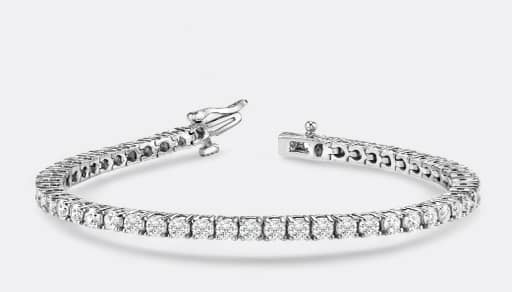 A silver tennis bracelet is pictured on a light grey backdrop.