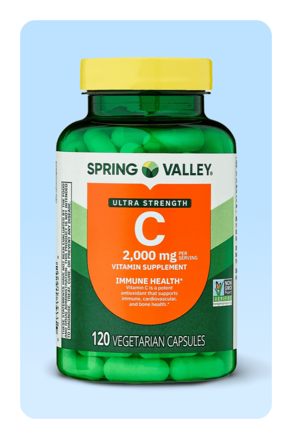 Image shows a green bottle of Spring Valley Ultra Strength Vitamin C capsules with a yellow lid on a light blue background.