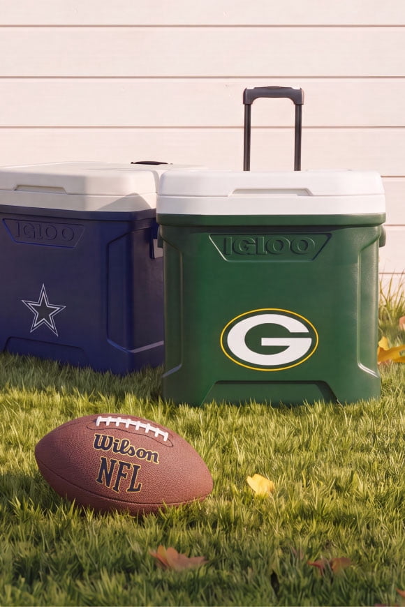 A blue Dallas cooler, next to a green Wisconsin cooler, sitting on grass next to a football.