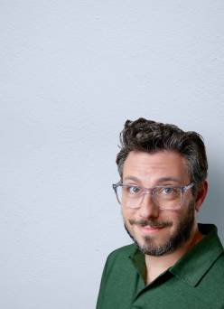 A man shown wearing clear eyeglasses. Advertising men’s frames.