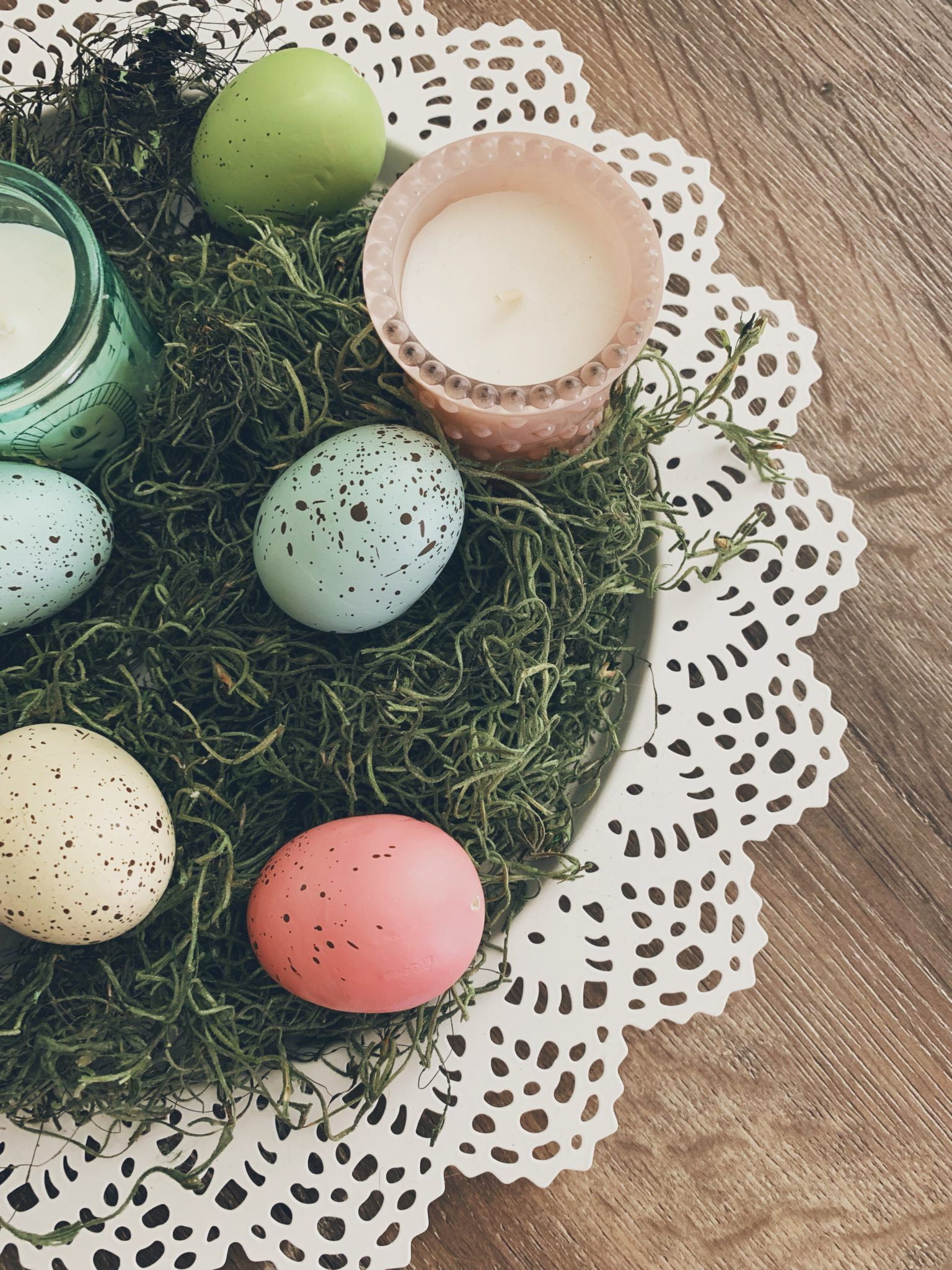 Create this easy Easter centerpiece with a lace charger, green moss, speckled eggs, and pastel candles. Simply arrange everything for a festive, rustic-chic touch—perfect for spring or Easter brunch!, Shop post, 
