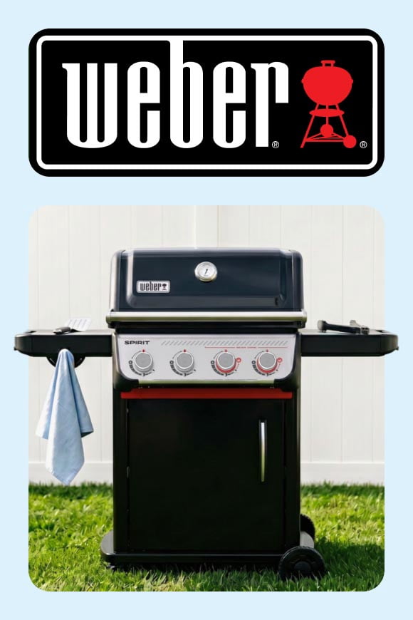 A grill on grass, in front of a white fence, across from the Weber logo.