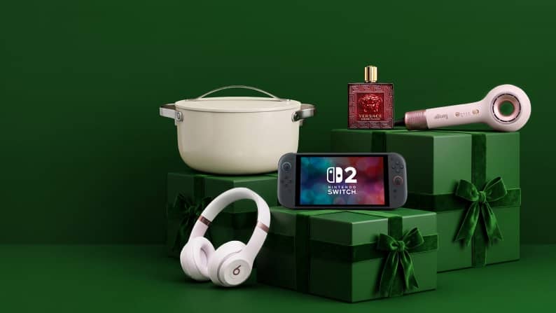 Nintendo Switch console with game, Beats headphones, white pot, perfume and beauty device arranged on gift boxes.