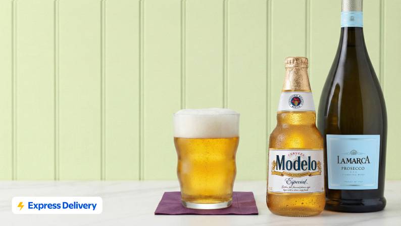 A glass of beer is shown next to a bottle of Modelo & a bottle of wine.