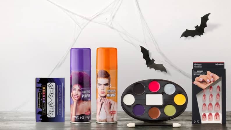 Spiderweb lashes, purple and orange hairspray, costume makeup and blood-themed press-on nails.