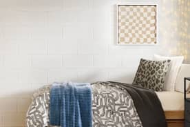 A stylish fully decorated dorm room with geometric print bedding.