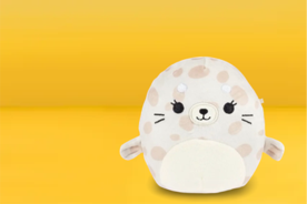 Image shows a beige and white Squishmallows plush toy with polka dots on a yellow background.